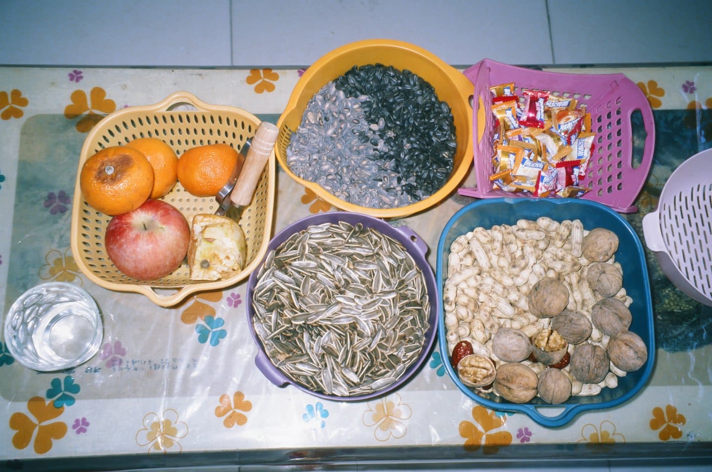 Variedad de bocadillos y frutas dispuestas sobre un mantel estampado.
